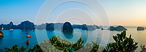 Panoramic view of boats floating in the tranquil waters of Halong Bay Vietnam at sunset
