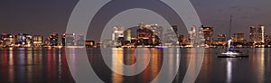 Panoramic view of Boston skyline and harbor at night with Atlantic Ocean on the foreground