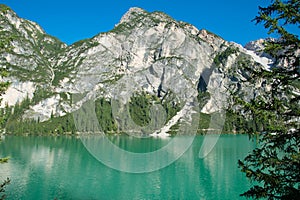 Panoramic view of Braies Lake in Dolomites mountains forest trail in background, South Tyrol