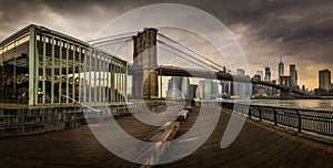 Panoramic view of Brooklyn Bridge against skyscrapers of New York on a gloomy day