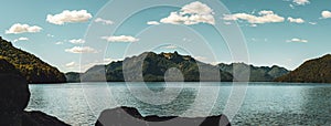 Panoramic view of a calm lake with a beautiful mountain range in the background. Lake Tromen. Neuquen, Argentina