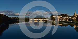 Panoramic view of calm Rhone river with famous historic bridge Pont Saint-Benezet in city Avignon, Provence, France.