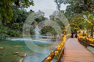 Panorámico de cascada sobre el balneario en translúcido inundado agua a exuberante vegetación 