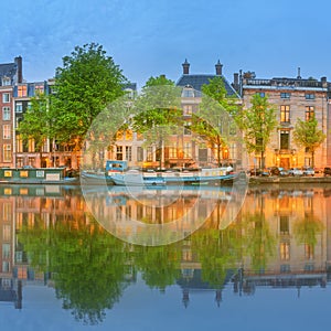 Panoramic view and cityscape of Amsterdam with boats, old buildings and Amstel river, Holland, Netherlands