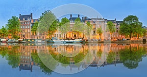 Panoramic view and cityscape of Amsterdam with boats, old buildings and Amstel river, Holland, Netherlands