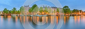 Panoramic view and cityscape of Amsterdam with boats, old buildings and Amstel river, Holland, Netherlands