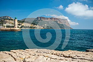Panoramic view on cliffs, blue sea, beach, houses, streets and old fisherman`s harbour with lighthouse in Cassis, Provence, Franc