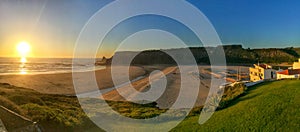 Panoramic view from the cliffs to surfer beach Praia de Odeceixe in the evening sun, District Aljezur - Algarve Portugal photo