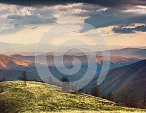 Panoramic view of colorful sunset in the mountains. Dramatic overcast sky.