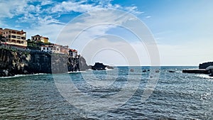 Panoramic view of colourful houses build on steep cliffs in fishermen village of Camara de Lobos on Madeira island