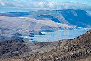 Panoramic view on colourful remote isthmus of Jandia peninsula and basal hills and mountains of Massif of Betancuria,