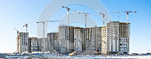 Panoramic view of the construction site with tall cranes of residential houses in the microdistricts