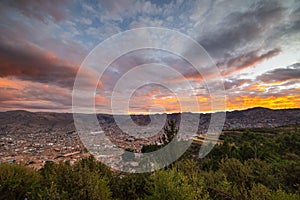 Panoramic view of Cusco town with glowing cloudscape and colorful sky at dusk. Cusco is among the most important travel destinatio