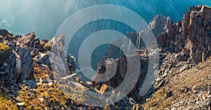 Panoramic view of dangerous couloir. Colorful sunny landscape with cliff and big rocky mountains and epic deep gorge