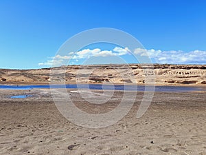 Panoramic view of desert landscape with lagoon and blue sky. Deserts and extreme nature