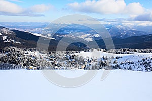 Panoramic view of Dragobrat ski resort from above. Mountain winter snowy landscape from ski slope. Wooden cottages and