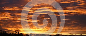 Panoramic view of dramatic fiery clouds at sunset