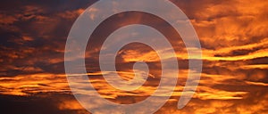 Panoramic view of dramatic fiery clouds at sunset