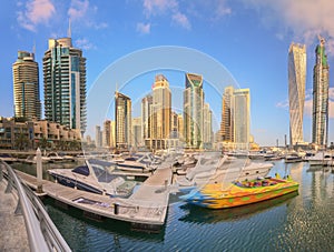 Panoramic view of Dubai Marina bay with yacht and cloudy sky, Dubai, UAE
