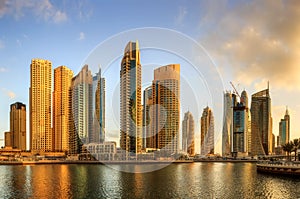 Panoramic view of Dubai Marina bay with yacht and cloudy sky, Dubai, UAE.