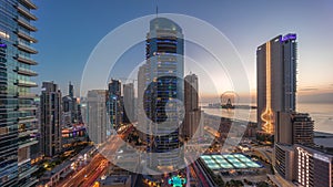 Panoramic view of the Dubai Marina and JBR area and the famous Ferris Wheel aerial day to night timelapse