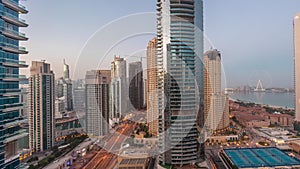 Panoramic view of the Dubai Marina and JBR area and the famous Ferris Wheel aerial night to day timelapse