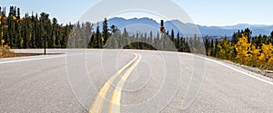 Panoramic view of an empty road winding through a mountain landscape in Colorado