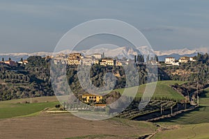 Panoramic view of Fabbrica di Peccioli, Pisa, Italy, with snow capped mountains in the background photo