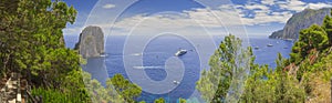 Panoramic view of famous Faraglioni Rocks and Marina Piccola in Capri island, Italy. Typical panoramic pedestrian path of Capri.