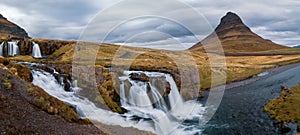 Panoramic view of Famous Kirkjufell mountain with Kirkjufellsfoss infront of it under morning sun light in Iceland during spring photo