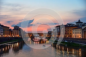 Panoramic view of famous Ponte Vecchio bridge with river Arno at sunset in Florence, Italy