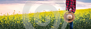 Panoramic view of farmer standing in blooming rapessed field