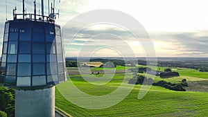 Panoramic view of farmers` fields, sunset and observation tower.