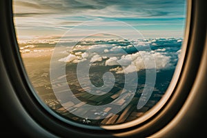 Panoramic view of fields and clouds from airplane window