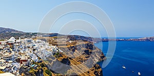 Panoramic view of Fira town on high coast among seascape, Santorini island in Greece