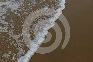 Panoramic view of foamy sea waves of Arabian Sea swashing on sandy Gokarna Main Beach, Karnataka, India