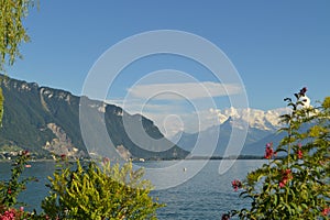 Panoramic view on Geneva Lake. Mountains, hills, greenery and blue sky. Switzerland