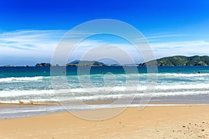 GERIBA BEACH, BUZIOS, RIO DE JANEIRO, BRAZIL: Panoramic view of the Geriba Beach in a sunny day. Blue sea with waves and golden sa photo