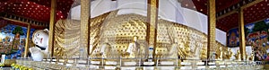 Panoramic view of golden reclining Buddha statue at Wat Bandensali temple in Thailand