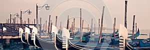 Panoramic view of gondolas and wooden pier in winter in Venice Italy