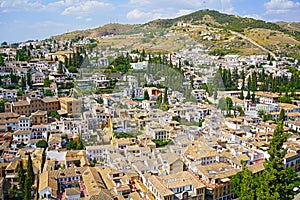 Panoramic view on Granada city suburbs and mountains on horizon from the castle, Spain.