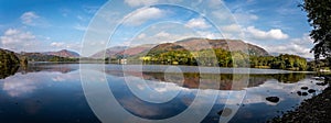 Panoramic view of Grasmere Lake with reflections  in The Lake District from the shore side in Cumbria