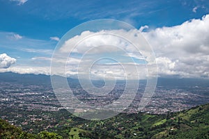 Panoramic view of the green and tree-filled mountains surrounding the capital of San Jose, Costa Rica on a sunny morning with photo