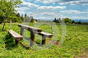 Panoramic view of green valley and rest area with wooden bench