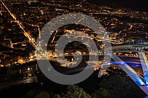 Panoramic view of Grenoble city illuminated at night and the cable car cabin`s shadows