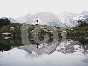Panoramic view of hiker at Guggersee alpine mountain lake reflection in Allgaeu alps near Oberstdorf Bavaria Germany