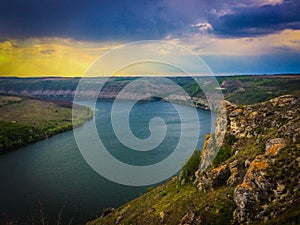 Panoramic view from the hill on bend of the river. Beautiful summer landscape. Colorful clouds of the morning sky. Dniester Canyon