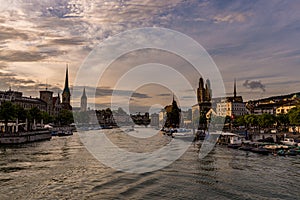 Panoramic view of historic Zurich downtown with Fraumunster and Grossmunster churches at lake zurich during sunset, Switzerland