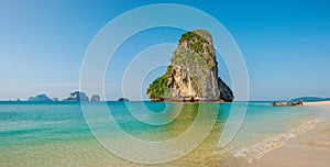 Panoramic view of idyllic Railay Beach in Thailand with rock islands and a traditional longboat