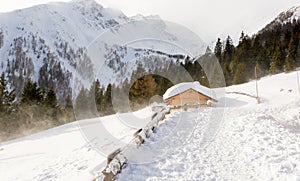 Panoramic view of idyllic winter wonderland with mountain tops and traditional mountain chalet in the Dolomites